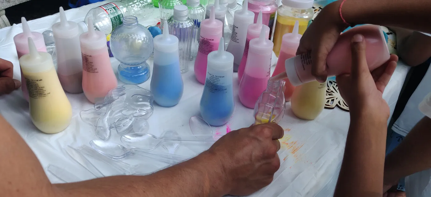 Guests working with colorful sand art bottles at a table